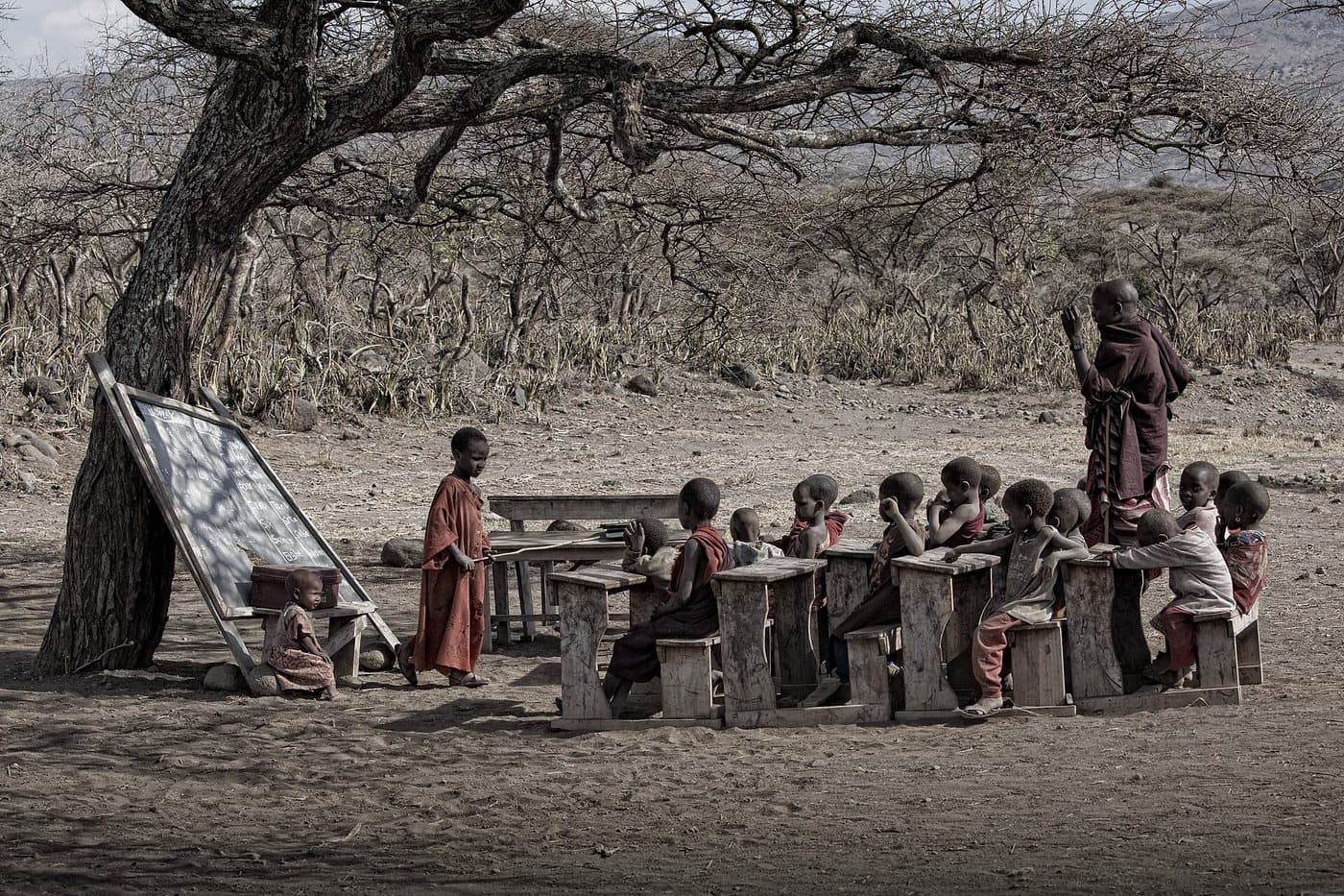Children seated in an outdoor classroom.