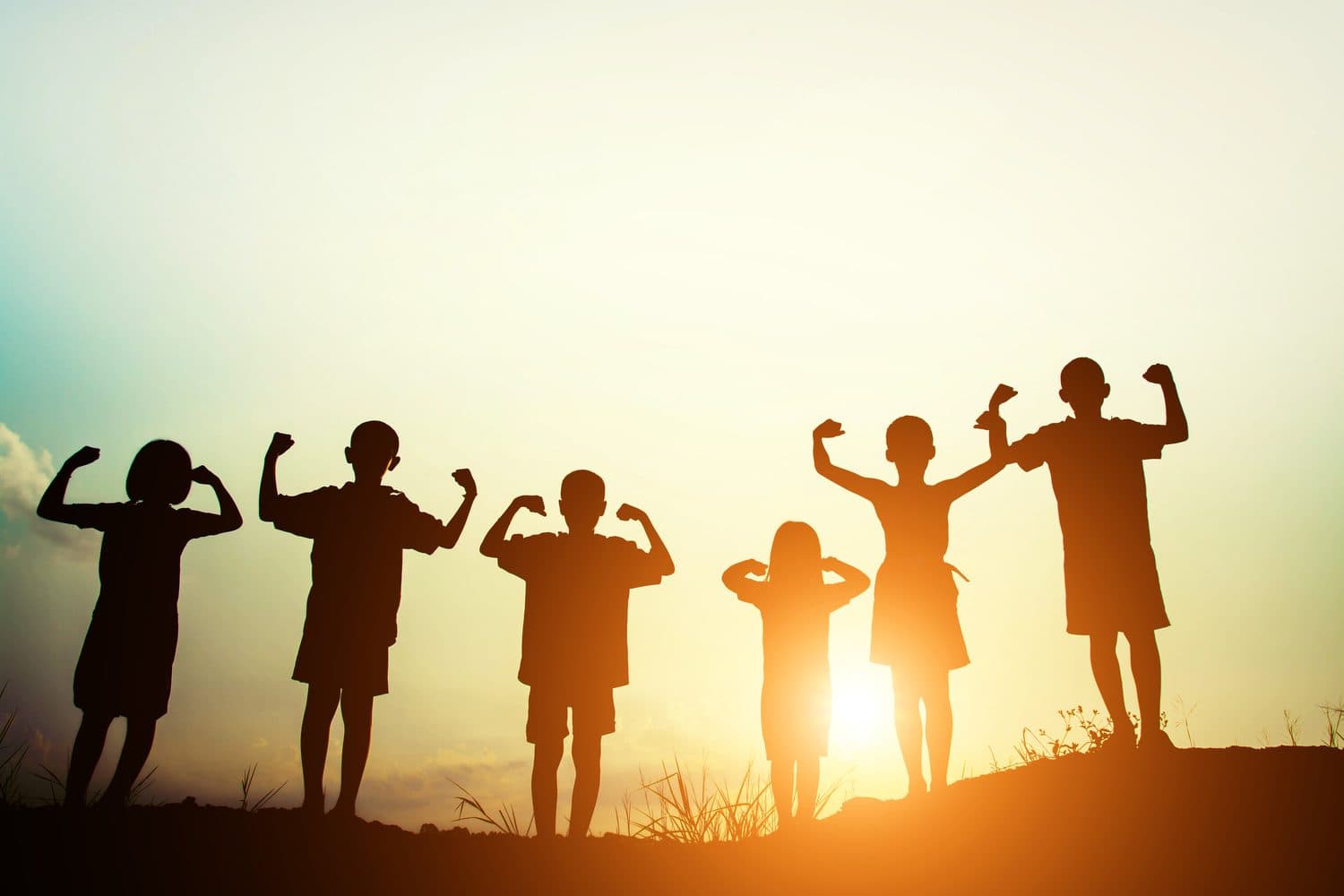 Children standing together in warm sunset light.